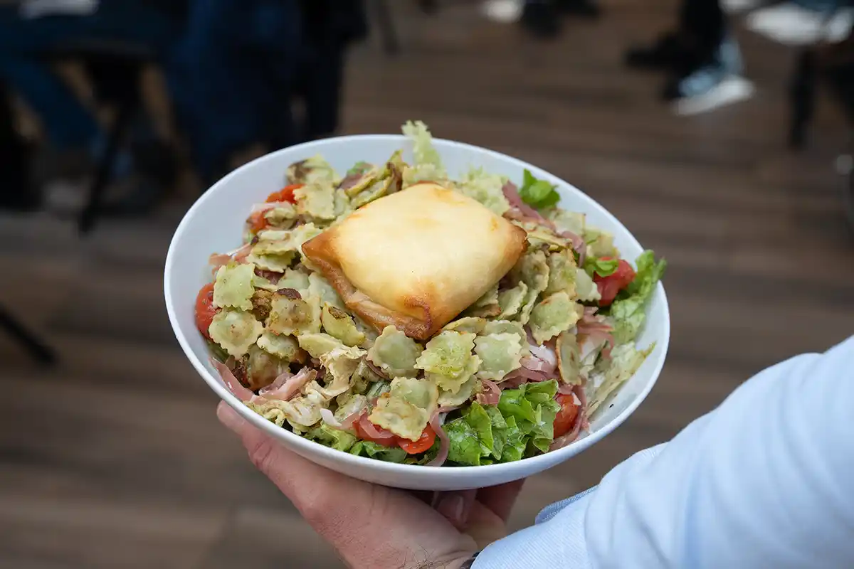 Exemple de plat à la carte avec une grande assiette de salade et ses ravioles